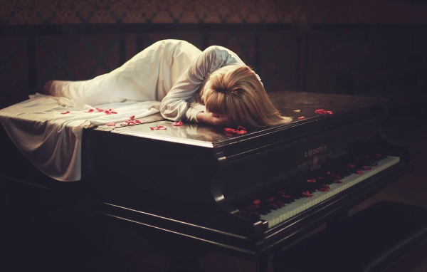 Девушка лежит на рояле