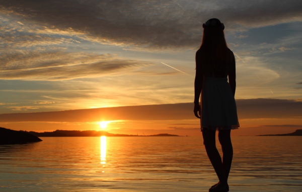 Девушка смотрит на закат в Норвегии