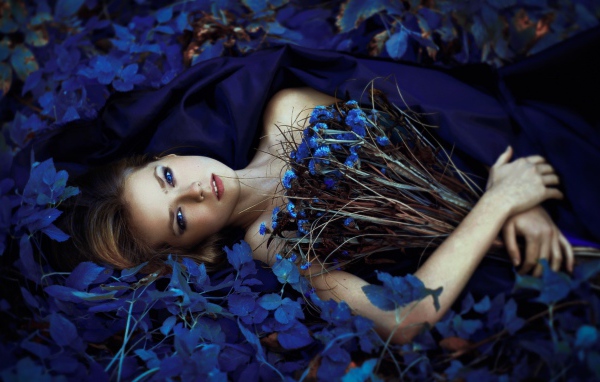 Девушка с букетом среди синих цветов