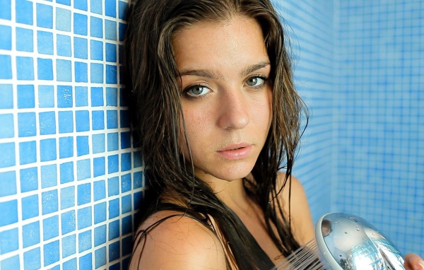 Зеленоглазая брюнетка стоит в душе