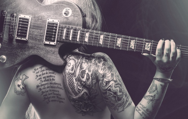 Гитара на спине татуированной девушки