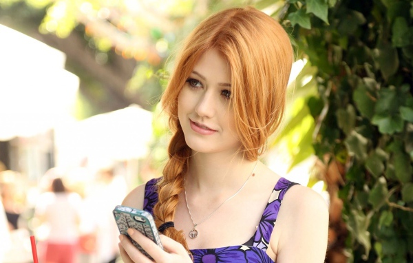 Девушка Кэтрин Макнамара с телефоном в руке