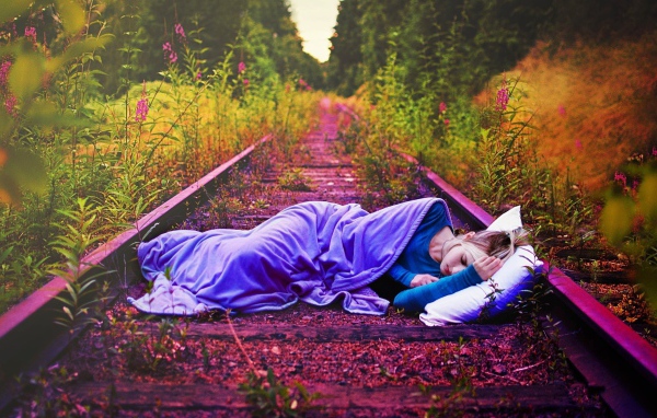 Девушка спит на заброшенных рельсах