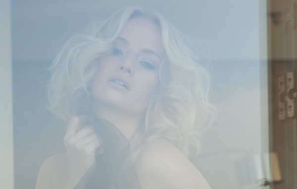 Блондинка с короткими волосами за стеклом