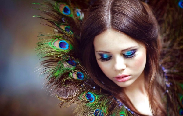 Воротник у девушки из перьев павлина