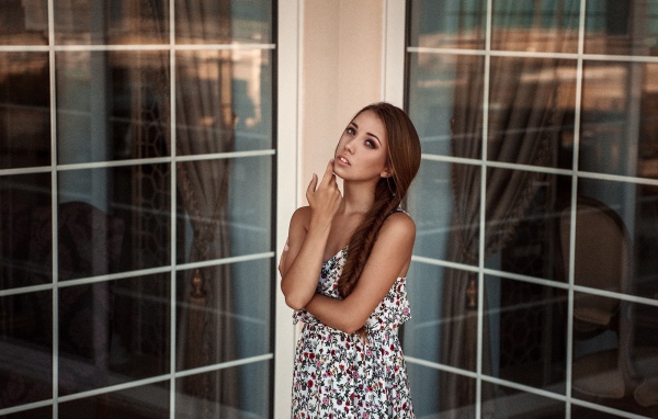 Девушка в углу между окнами