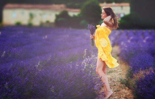 Девушка в желтом парео с букетом на лавандовом поле