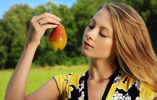 Девушка смотрит на грушу