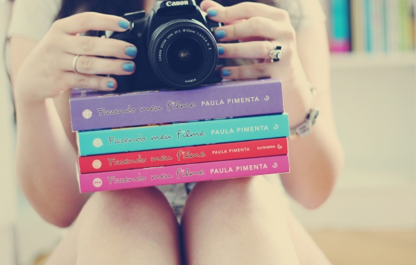 Девушка фотограф со стопкой книг