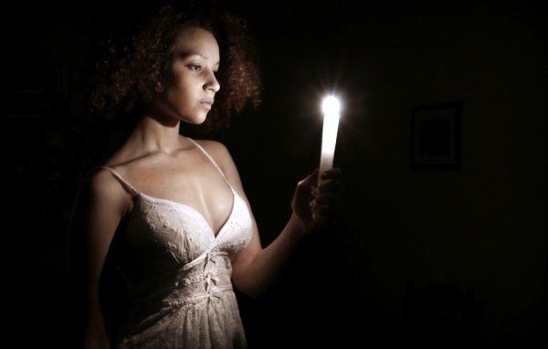 Девушка со свечой в темноте
