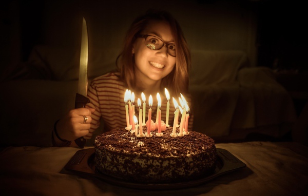 Девушка с ножом у праздничного торта