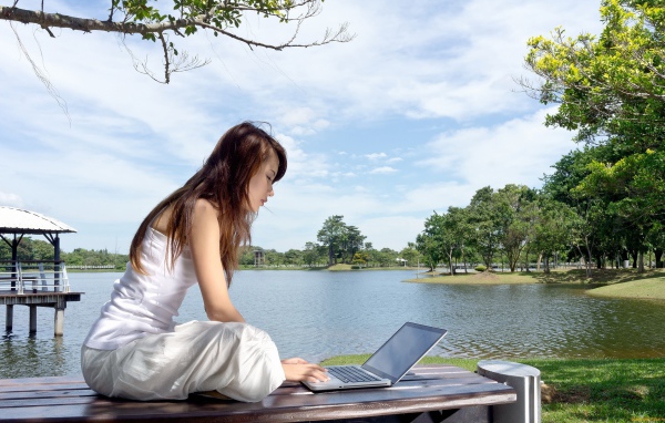 Девушка с ноутбуком у озера