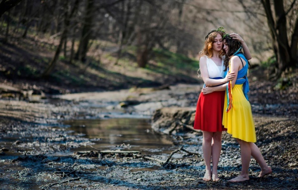 Две девушки в ярких платьях в чаще леса