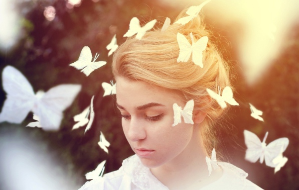 Белые бабочки летают вокруг девушки