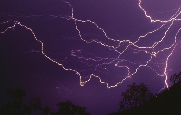 Молнии в фиолетовом небе ночью