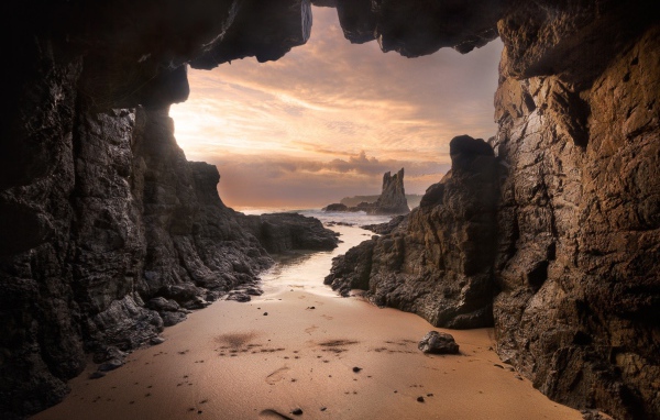 Мокрый песок у входа в пещеру