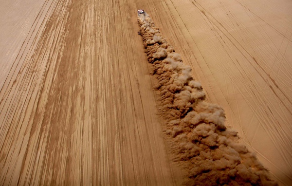 Облако пыли за автомобилем в пустыне