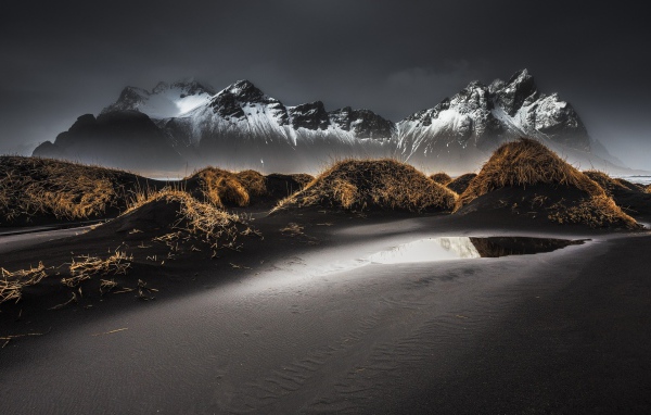 Серый песок на фоне гор