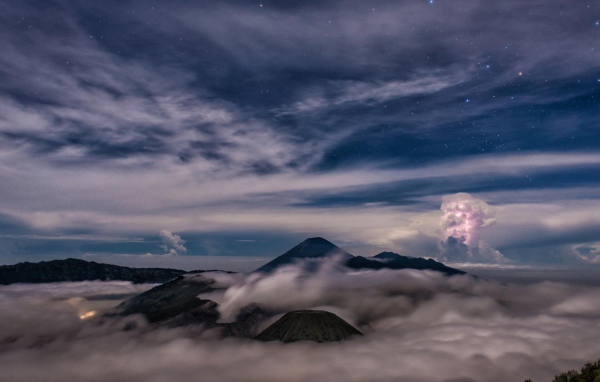 Звездное небо над облаками и туманом в горах