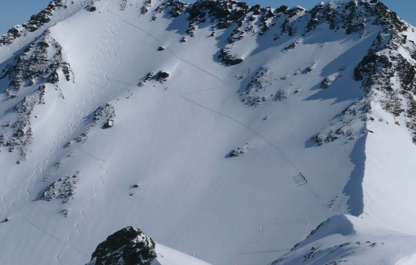 Следы лыжников на горном склоне