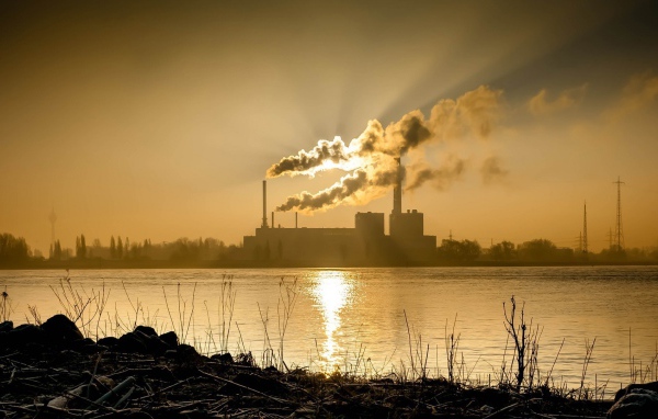 Лучи солнца пронизывают дым из заводских труб
