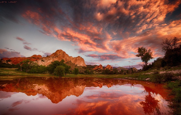 Облака отражаются в коричневой воде озера