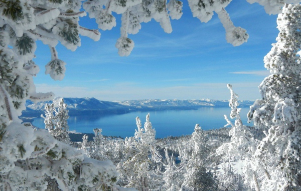 Горное озеро в рамке из заснеженных ветвей