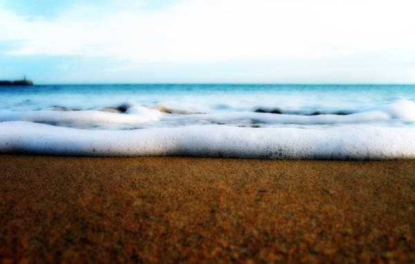 Белая пена волны у берега