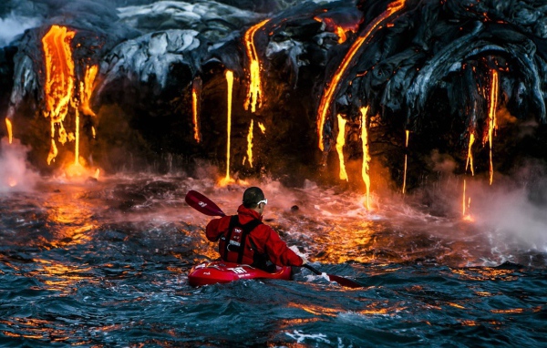 Man on the background of lava flowing into the sea