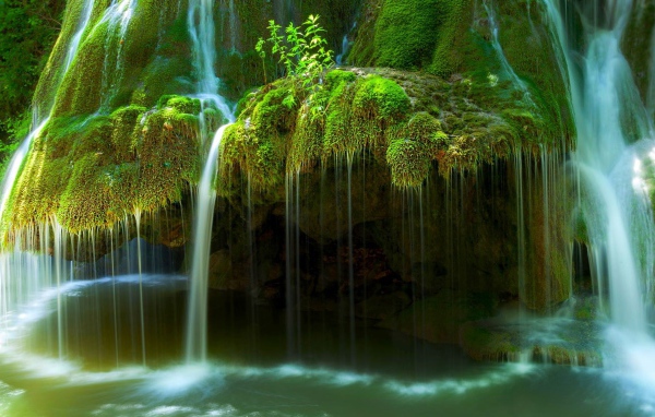 Вода стекает по покрытым мхом скалам