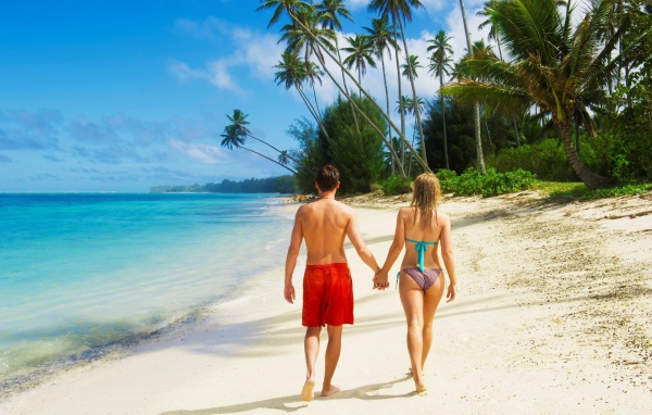 Парень и девушка идут по пляжу