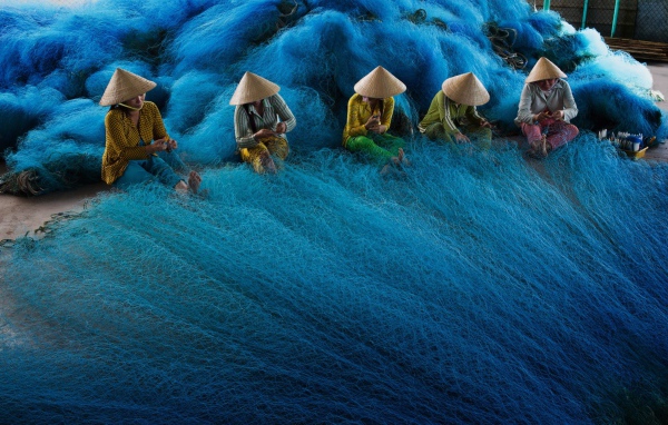 Vietnamese women weave fishing nets