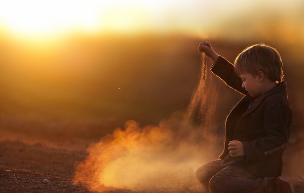 Мальчик играет песком