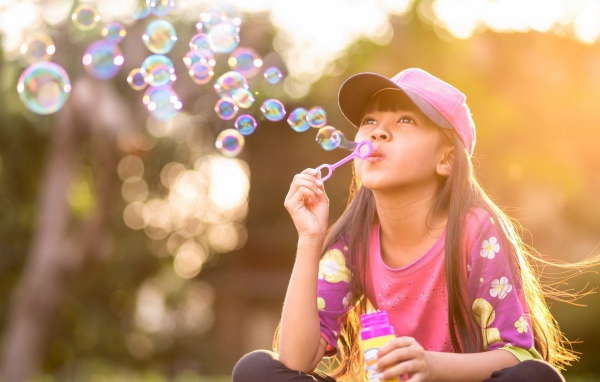 Девочка запускает мыльные пузыри