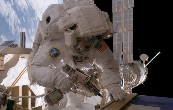 Космонавт на орбите выполняет ремонт