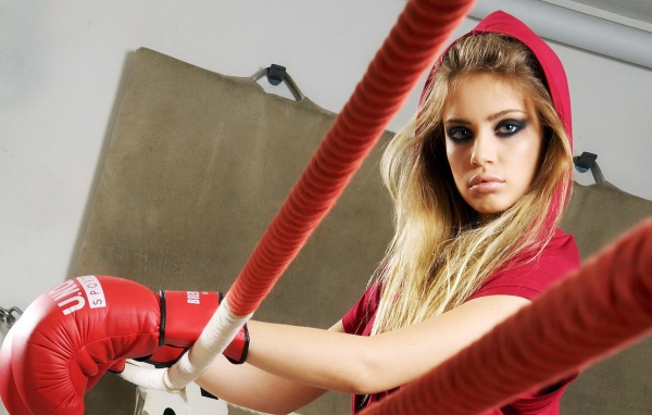 Блондинка в перчатках на боксерском ринге