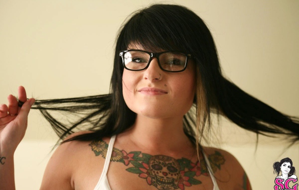 Брюнетка в очках с тату на груди