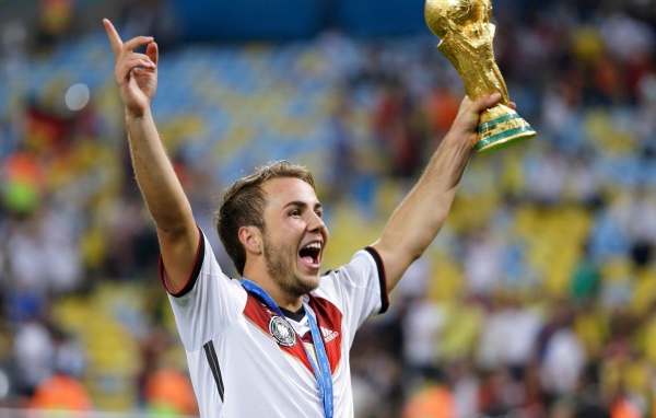 Немецкий футболист Марио Гётце держит в руке кубок