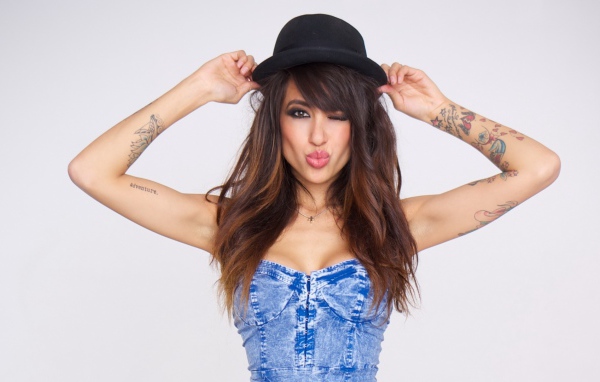 Girl in a black hat with a tattoo on hand