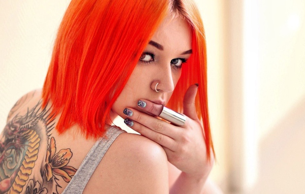 Girl with orange hair and a tattoo on her back