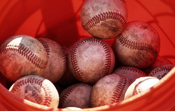 Красное ведро с мячами для бейсбола