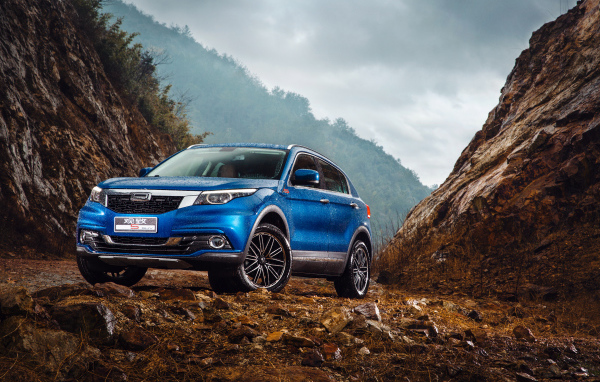 Синий китайский автомобиль Qoros 5  под дождем