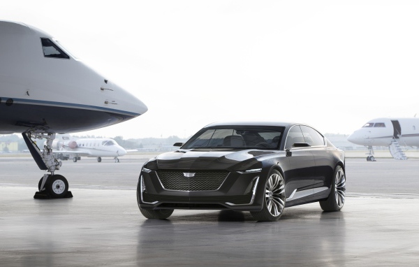 Черный стильный автомобиль Cadillac Escala на фоне самолетов