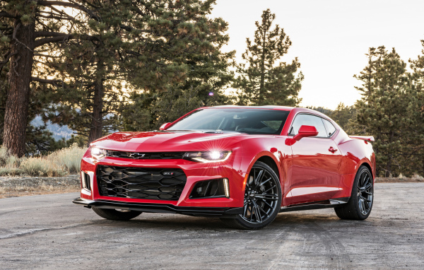 Красный автомобиль Chevrolet Camaro ZL1 на фоне леса 