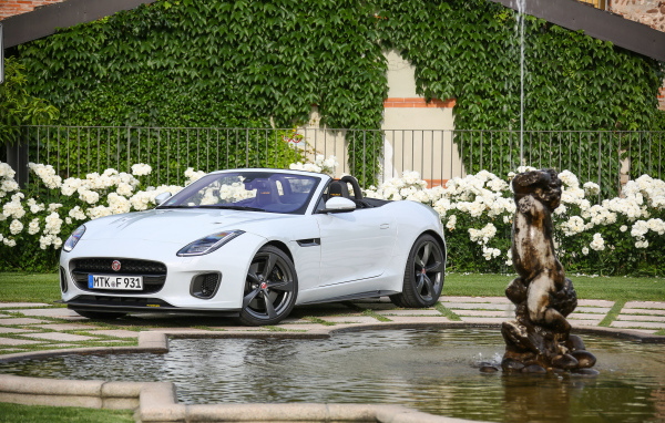 Белый автомобиль кабриолет Jaguar F-Type у фонтана