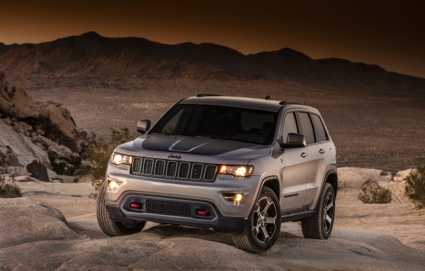 Серебристый внедорожник Jeep Grand Cherokee в пустыне 