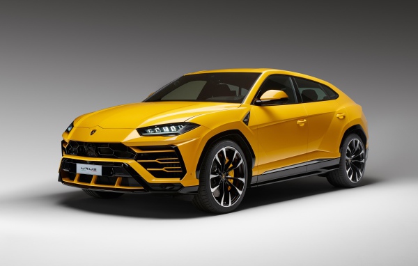 Желтый спортивный автомобиль Lamborghini Urus, 2018 на сером фоне