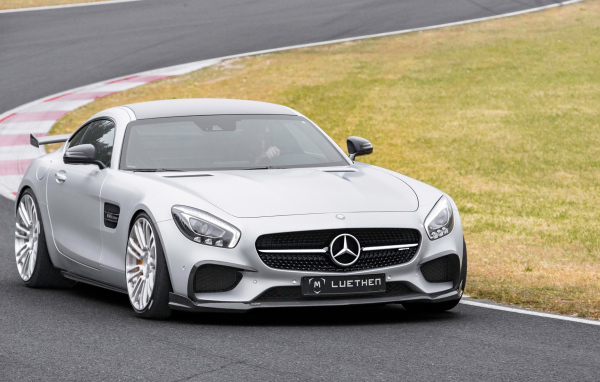 Серебристый автомобиль Mercedes-AMG GT на трассе