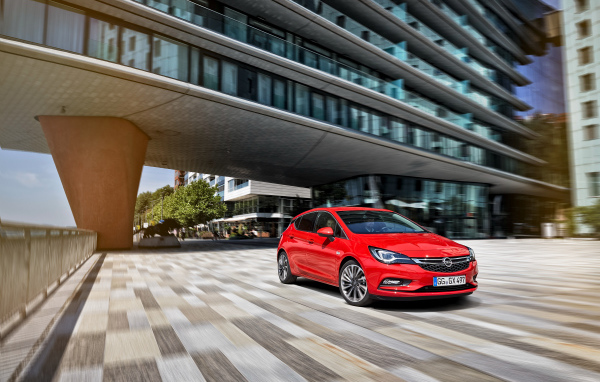 Красный автомобиль Opel Astra в движении