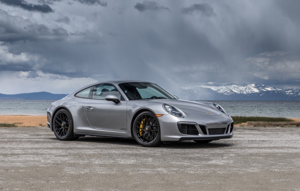 Серебристый автомобиль Porsche 911 Carrera 4 GTS Coupe на фоне грозового неба